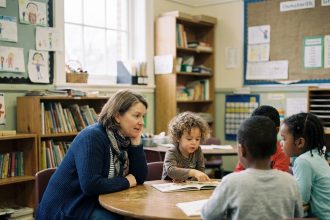 Enseignante chaleureuse avec enfants en classe primaire